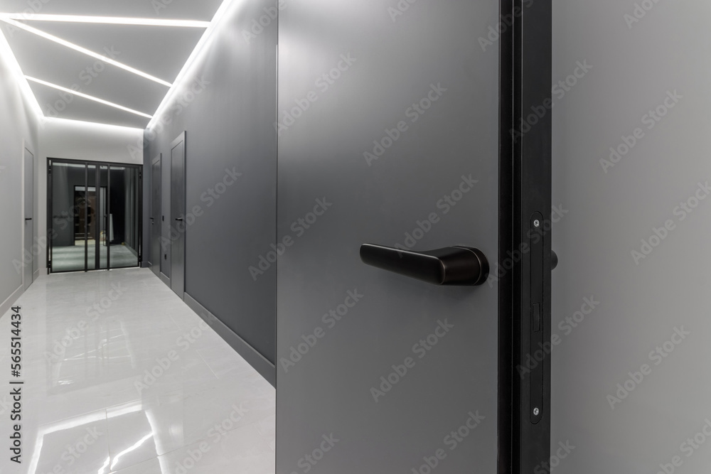 Simple clean newly built generic modern new real estate block of flats interior, long black corridor with black doors, perspective. New bought apartment, new home, hallway abstract concept, copy space Simple clean newly built generic modern new real estate block of flats interior, long black corridor with black doors, perspective. New bought apartment, new home, hallway abstract concept, copy space