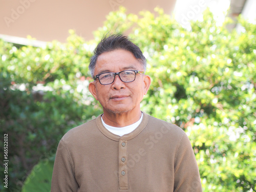Portrait of middle-aged asian man wearing glasses happy in outdoor.