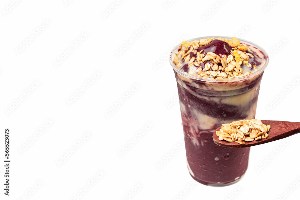 Acai bowl with banana and a spoonful of granola on white background. Acai bowl with banana and a spoonful of granola on white background.