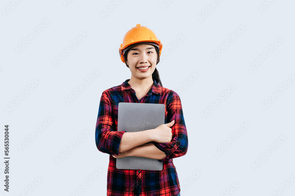 Young female engineer wearing Yellow helmet and use laptop computer Young female engineer wearing Yellow helmet and use laptop computer
