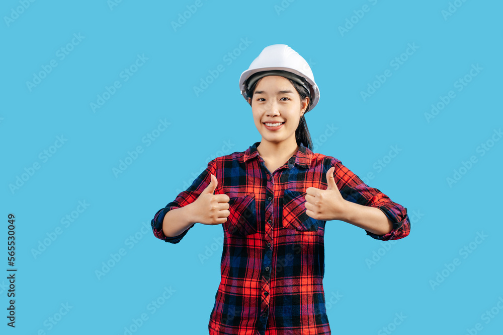 Young female engineer in helmet stand with thumb up posture Young female engineer in helmet stand with thumb up posture