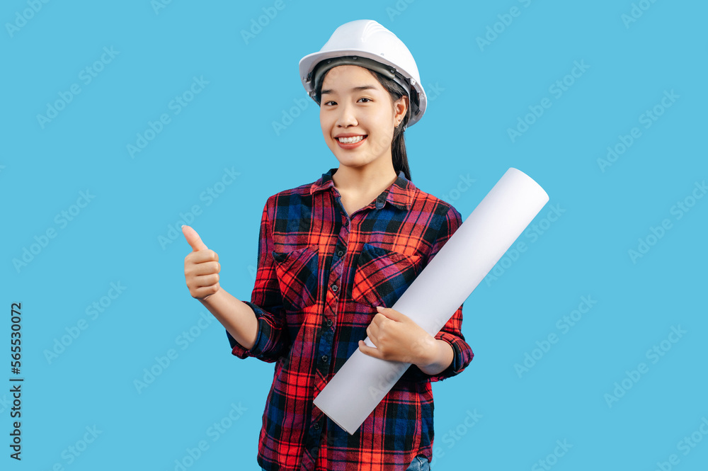 Young female engineer wearing white safety helmet with Blueprints Young female engineer wearing white safety helmet with Blueprints