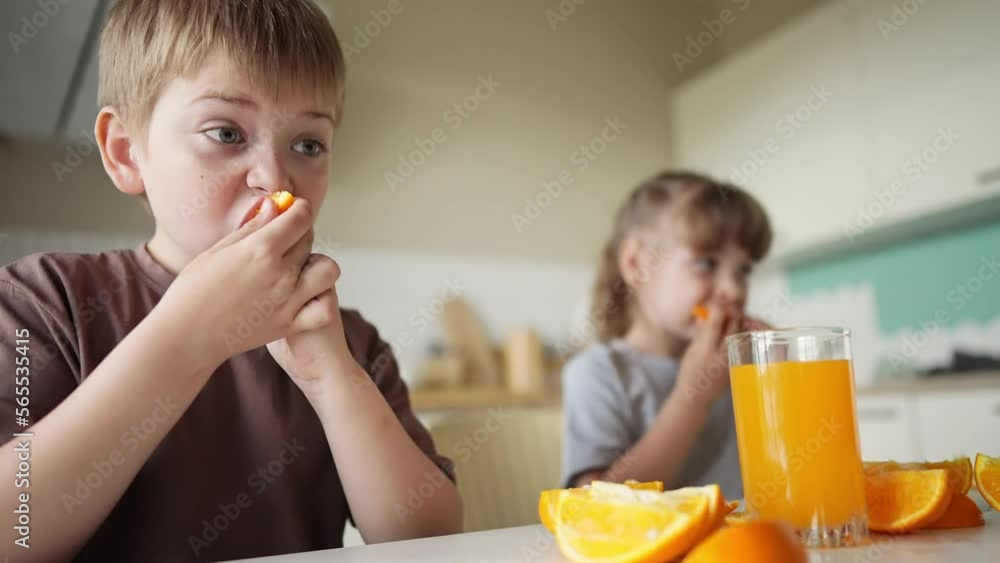 children eat oranges. happy family a kid dream concept. drinking fresh juices. morning breakfast brother and sister eat oranges in lifestyle the kitchen. fruits orange juice healthy eating children eat oranges. happy family a kid dream concept. drinking fresh juices. morning breakfast brother and sister eat oranges in lifestyle the kitchen. fruits orange juice healthy eating