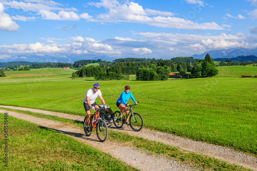 Eltern mit Nachwuchs im Buggy unterwegs mit dem Mountainbike  die Voralpen-Landschaft im Allg  u genie  en 