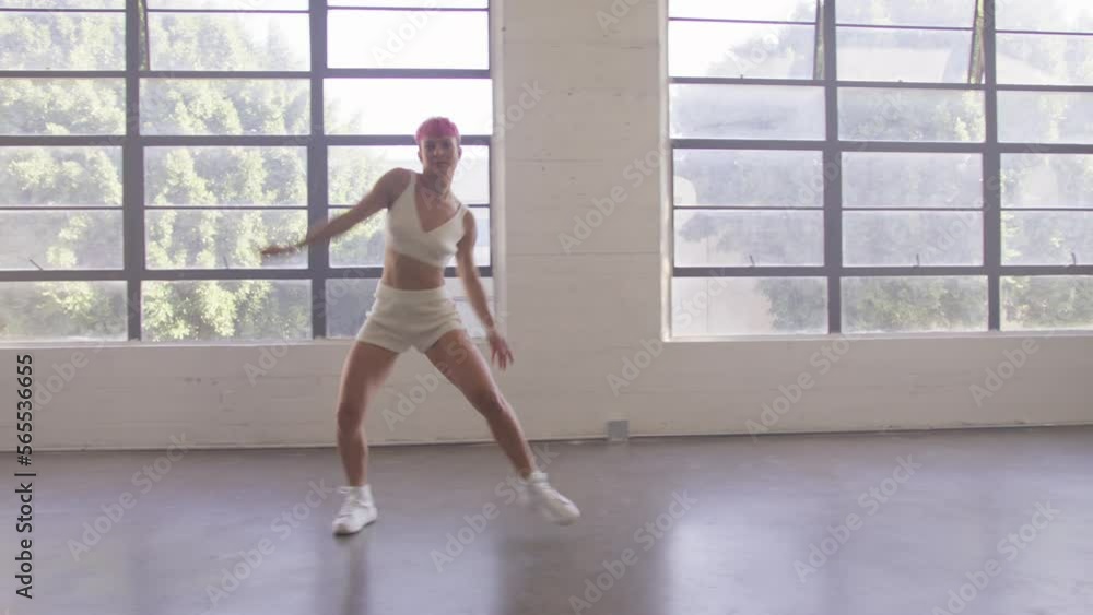 Happy beautiful caucasian woman walking and dancing indoor. Young carefree girl with short pink hair enjoys day and dancing in urban dance studio. Funky lady performing dance walk dolly shot 4K RED Happy beautiful caucasian woman walking and dancing indoor. Young carefree girl with short pink hair enjoys day and dancing in urban dance studio. Funky lady performing dance walk dolly shot 4K RED