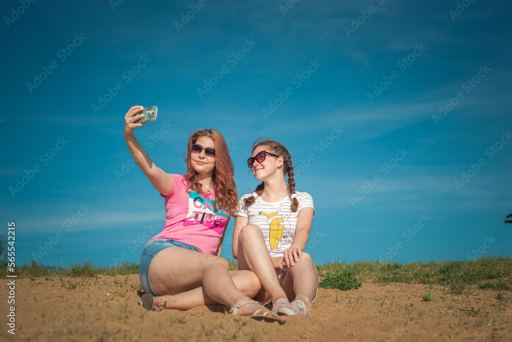 Portrait of young beautiful girlfriends in a summer park. Portrait of young beautiful girlfriends in a summer park.