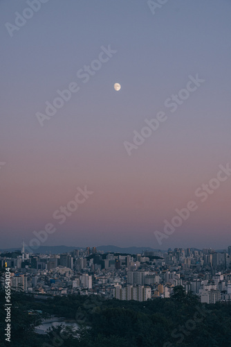 Gradient sky and bright moon over the city