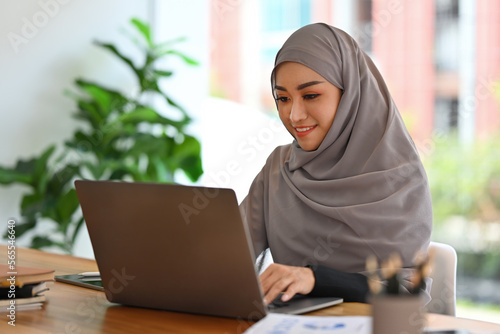 Young Muslim Businesswoman with hijab working with laptop and doing financial report.