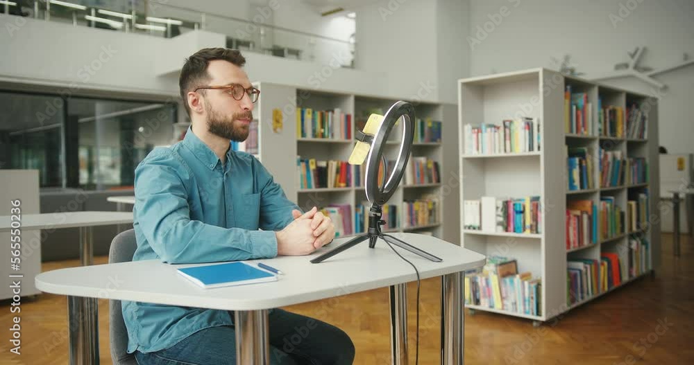 Bearded man conducts online meeting with colleagues at table Bearded man conducts online meeting with colleagues at table