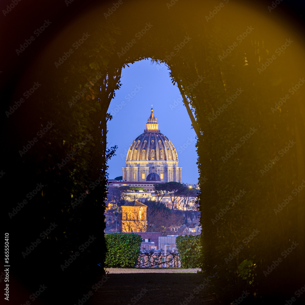 View of the Vaticana and St Peter basilica through a tree line and a door  keyhole,