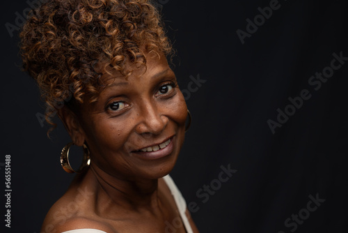 Closeup portrait of a beautiful retired elderly African American female  widow in her 70s with smiling expression and personality, one