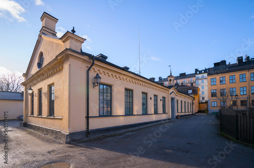 Old yellow 1850s houses at the block Kungliga Myntet, royal mint, facades, chimneys, and dorms a winter day in Stockholm