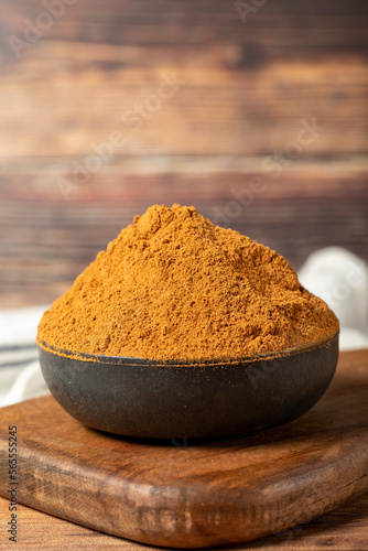 Powdered cinnamon spice. Ground cinnamon in a bowl on a wooden background. Dry spice concept. close up