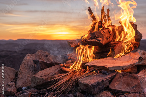 Burning wood at dawn. Atlas Mountains on the background