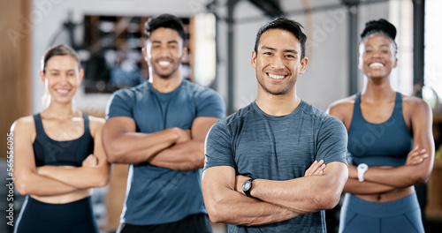 Fitness  portrait and man personal trainer with clients standing with crossed arms in the gym. Sports  collaboration and happy people after exercise  workout or training class in sport studio.