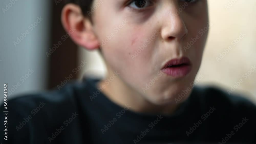 Young boy eating lunch. Portrait face closeup child eats food. Preteen seated at meal table Young boy eating lunch. Portrait face closeup child eats food. Preteen seated at meal table