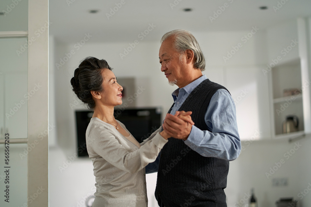 loving asian old couple dancing at home