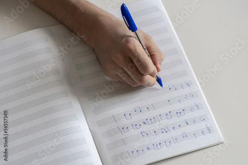 student in music school write down musical notes in notebook