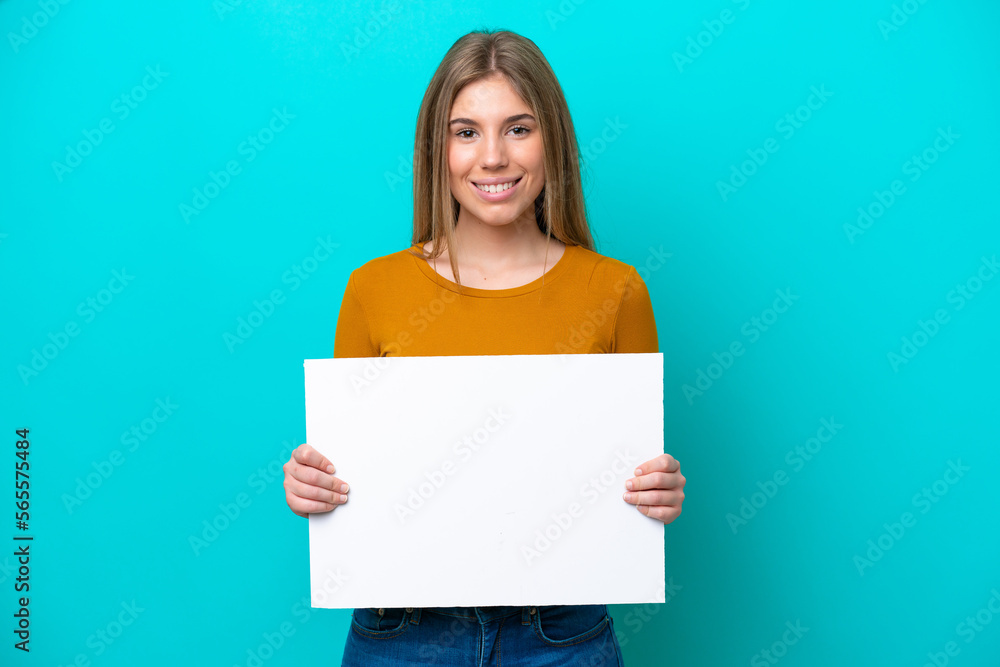 Young caucasian woman isolated on blue background holding an empty placard with happy expression Young caucasian woman isolated on blue background holding an empty placard with happy expression