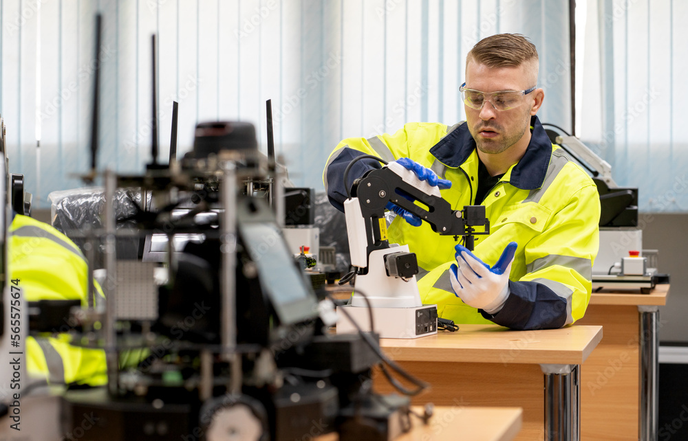 Computer science development engineer working on robotic arm connection and control at electronic futuristic technology center. Modern people training in industry 4.0 automated engineering workshop Computer science development engineer working on robotic arm connection and control at electronic futuristic technology center. Modern people training in industry 4.0 automated engineering workshop