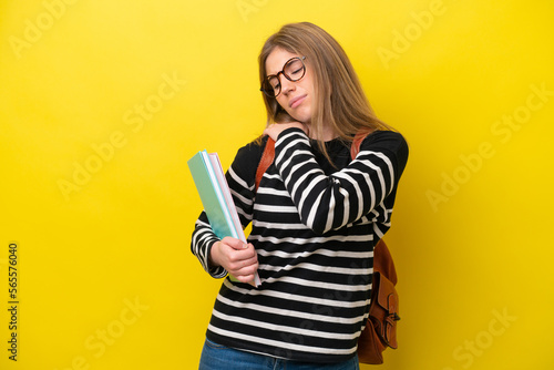 Young student woman isolated on yellow background background suffering from pain in shoulder for having made an effort