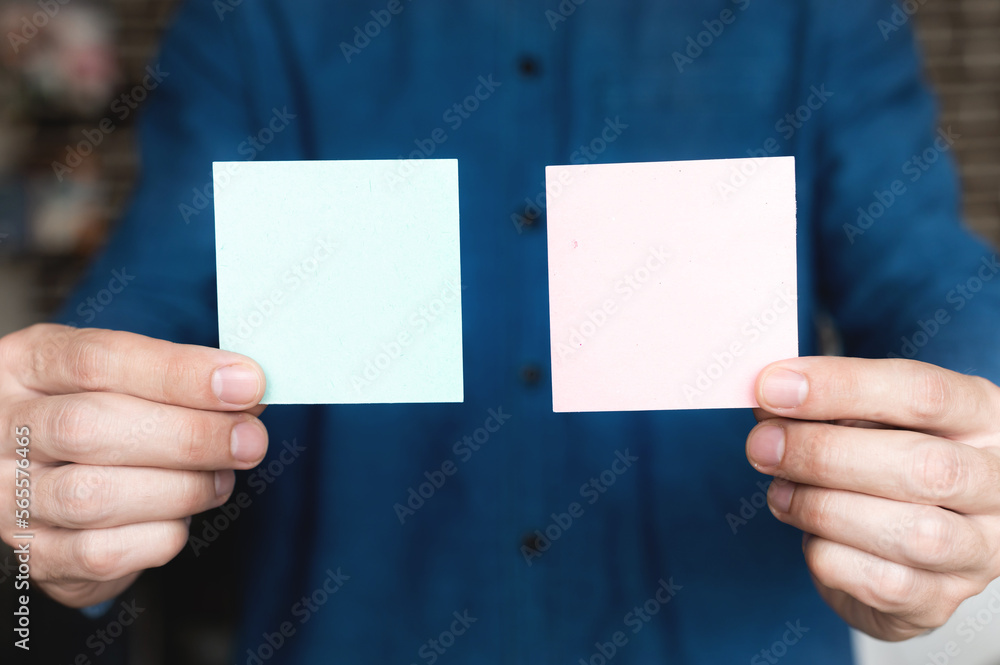 Close-up of male hands holding colorful sticky notes, for idea strategy brainstorming. Concept of office sticker for notes Close-up of male hands holding colorful sticky notes, for idea strategy brainstorming. Concept of office sticker for notes