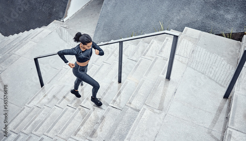 Training, above and woman running on stairs for power, sports and body energy in the city. Challenge, exercise and athlete runner with cardio on steps for a marathon, health and workout performance