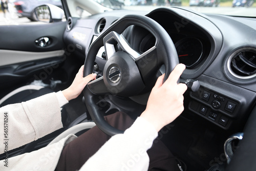 車のハンドルを握る女性の手元 © koumaru