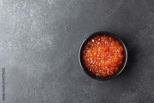 Red caviar in a black bowl
