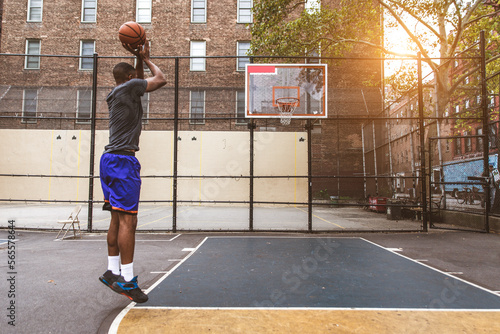 Athletic african american basketball player training on a court in New York - Sportive man playing basket outdoors