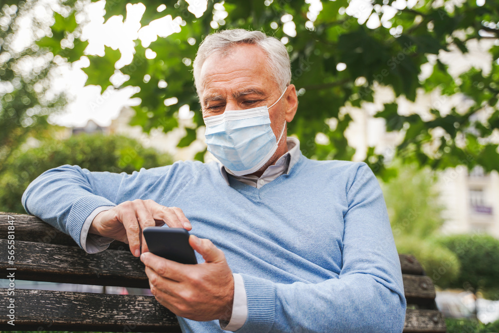 Senior man with face mask in a park during pandemic quarantine Senior man with face mask in a park during pandemic quarantine