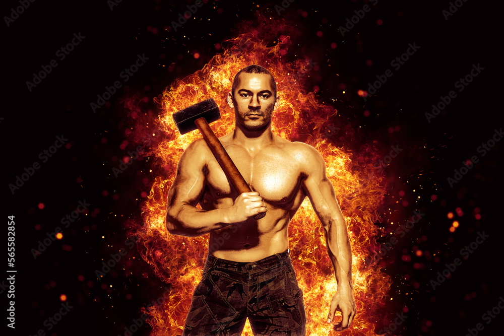 Strong man with naked torso holds a sledgehammer while isolated on burning background. Copy Space 