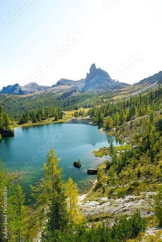 Aussicht auf t  rkisen See und gr  nen Wald mit Felsmassiv in den Dolomiten.