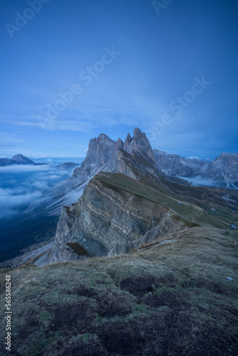 Felsmassiv in den Dolomiten in den Alpen mit Gras im Vordergrund. photo