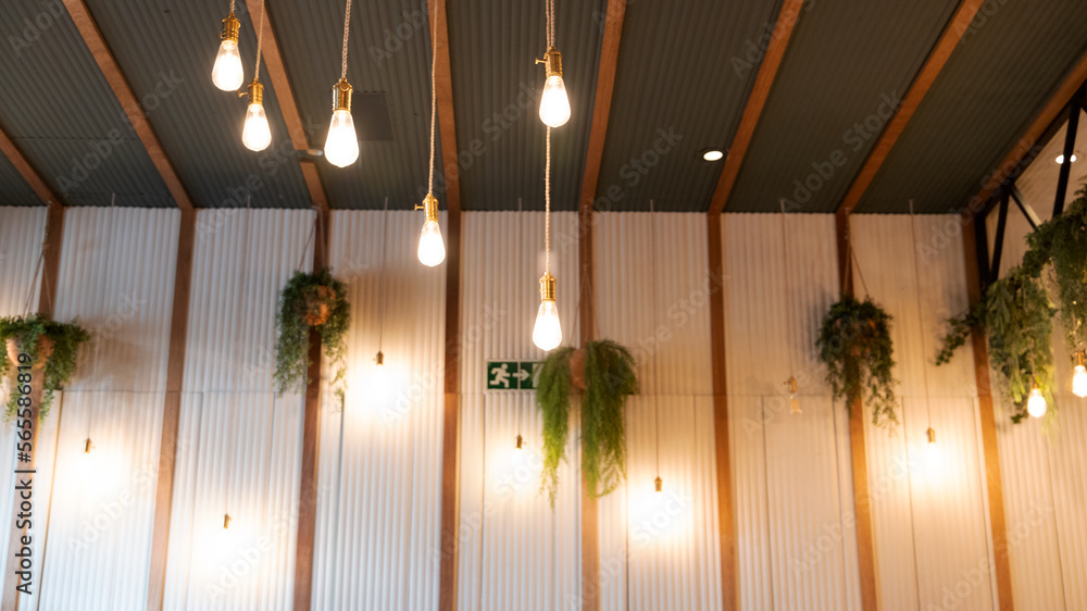 space decorated with light bulbs, plants and wooden slats