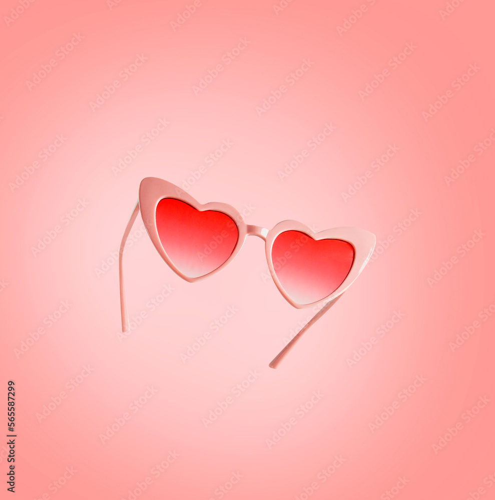 Pink heart shape Valentines day sunglasses flying at pink background