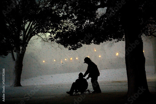 Two sledders are seen through a blowing snowstorm on the grounds of the U.S. Capitol photo