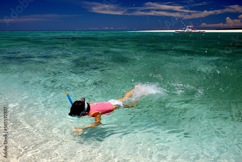 little girl doing snorkeling in White Island (locally known as Medano Islet or Medan Island) lies just 1.4 km, about 10 minutes, off the coast of Mambajao photo