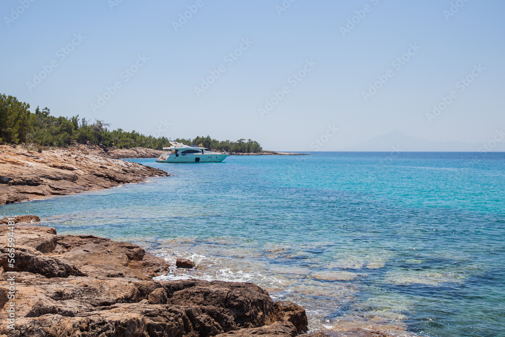 Breathtaking view of clear turquoise color of sea, seascape with yachts at bay. Clear blue sky on a sunny day. Summer travel holidays concept. Panoramic view. Greece shoreline.