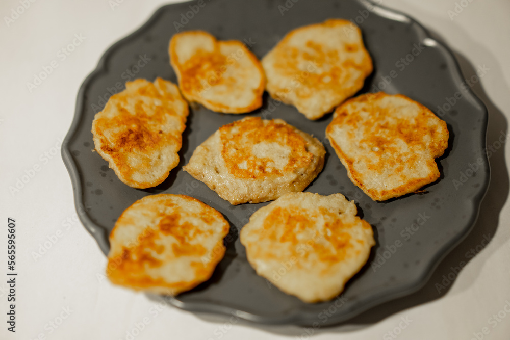 Small yellow mini banana pancakes on grey dish Small yellow mini banana pancakes on grey dish