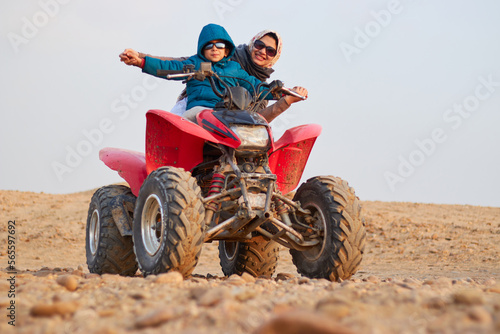 Giza, Egypt - mother and her child doing a desert safari riding beach buggy around the pyramids in the Cairo, Egypt.
