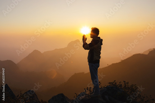 Male Travel praying alone on top mountain sunset background Lifestyle spiritual relaxation emotional concept vacations outdoor harmony with nature landscape