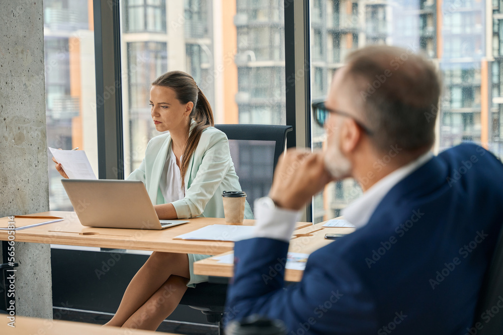 Two office workers sharing office and focused at work