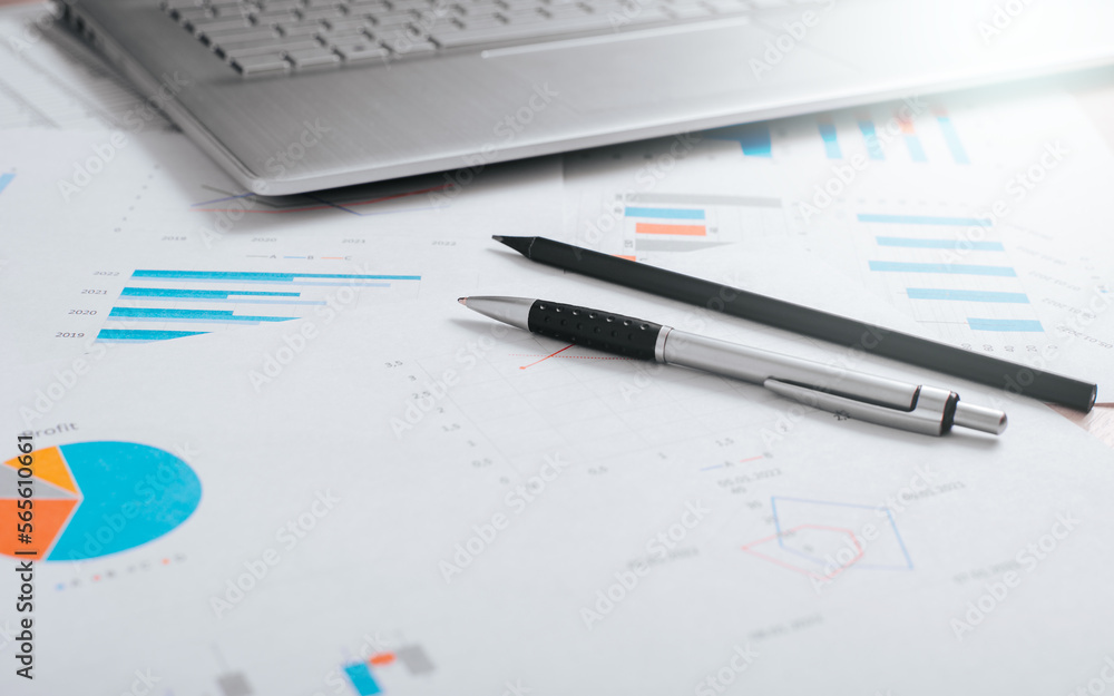 Accounting and finance concept. Close-up of pen, pencil, laptop and business documents at the workplace. Low angle view, selective focus