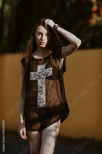 teenage girl with long hair poses; slender figure of a beautiful girl with emotional facial expressions; sunglasses on the head; a person against the background of a city landscape;