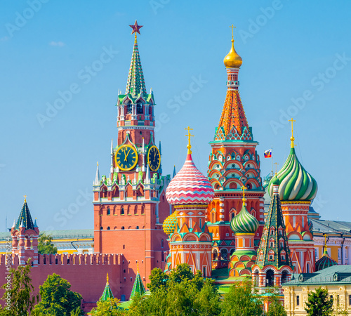 Spasskaya Tower of Moscow Kremlin and domes of the Cathedral of Vasily the Blessed (Saint Basil's Cathedral) on Red Square in sunny summer day. Moscow. Russia