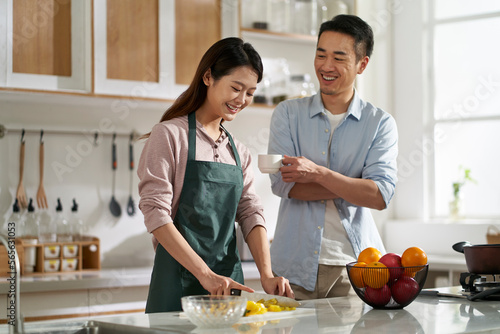 Canvas Print young asian couple talking chatting in kitchen
