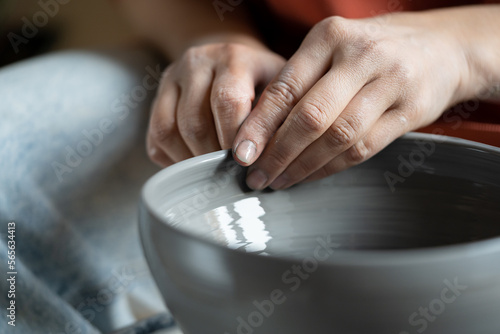 фотографія Close up of female hands molding wet clay on wheel, shaping final pottery product, potter making unique handmade stoneware, selective focus