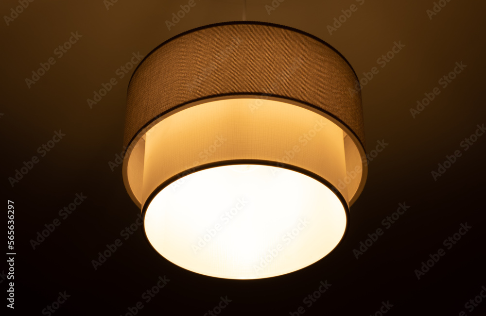 bright lamp burning in a round lampshade, lampshade lighting indoors on a dark background bright lamp burning in a round lampshade, lampshade lighting indoors on a dark background