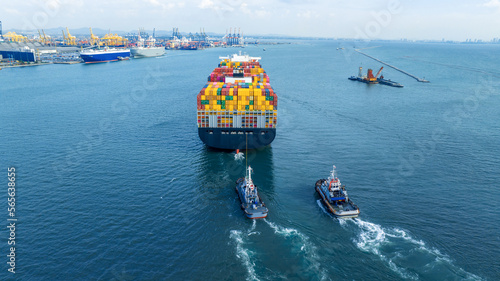 Tub Boat with Stern of cargo ship carrying container and running for import goods from cargo yard port to custom ocean concept technology transportation , customs clearance.